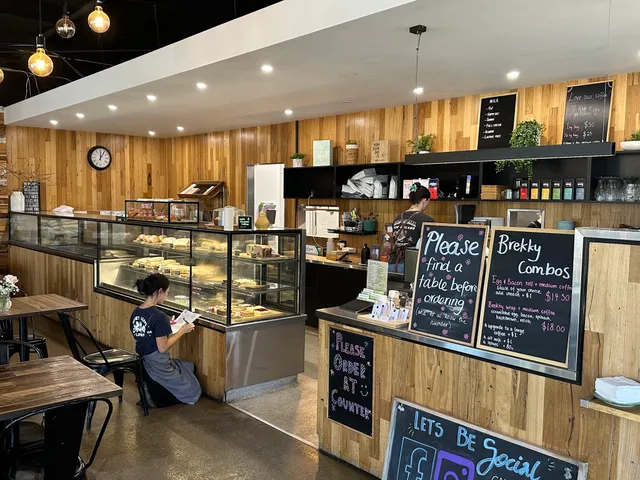 One Pear Tree cafe interior with timber walls, counter, baked goods display and staff member